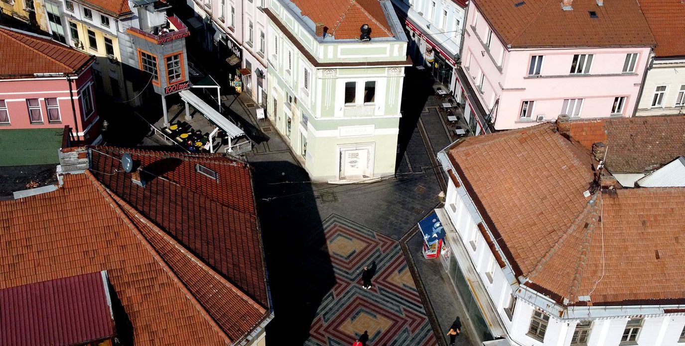 The old town from above, tiled roofs and a mosaic-paved street